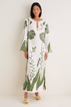 Woman wearing a classic, effortless Green Floral Border Que Energia Tunic Dress with wide sleeves, styled with fun floral sandals and high-end accessories.