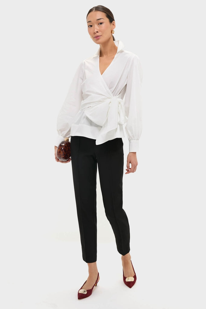 Model showcases the classic Black Audrey Pants, offering an effortless high-end look. Paired with a wrap blouse and heels, it's perfect for fun, polished styling.