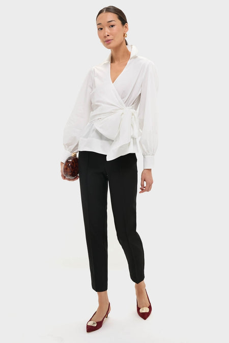 Model showcases the classic Black Audrey Pants, offering an effortless high-end look. Paired with a wrap blouse and heels, it's perfect for fun, polished styling.
