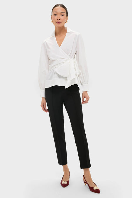 Model wearing Black Audrey Pants with a classic, slimming fit, styled effortlessly with a white wrap blouse and burgundy slingback shoes, exuding high-end, fun sophistication.