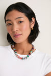 Young woman wearing the Multi Kairi Necklace—a classic, high-end, effortless statement piece with colorful hand-carved stones and gold-plated accents, ideal for fun, stylish occasions.