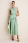 Young woman in a classic sleeveless dress, carrying a woven handbag, wears high-end Chestnut Suede Pasina Wedges, effortlessly blending fun and elevated style.