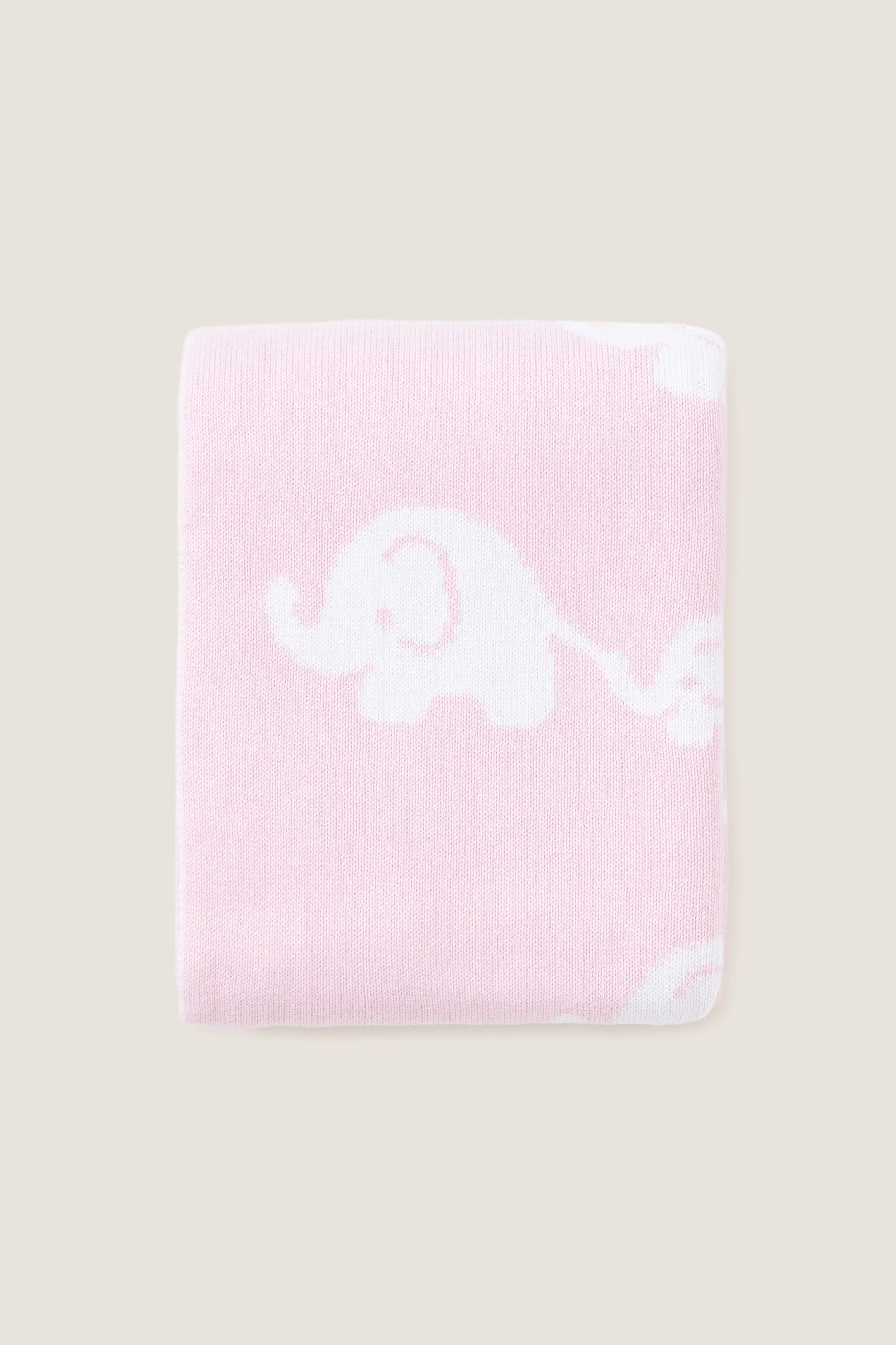 Pink Elephant Knit Blanket, featuring classic white elephant silhouettes on soft pink. Made from high-end, ultra-soft cotton for effortless comfort and fun snuggles.