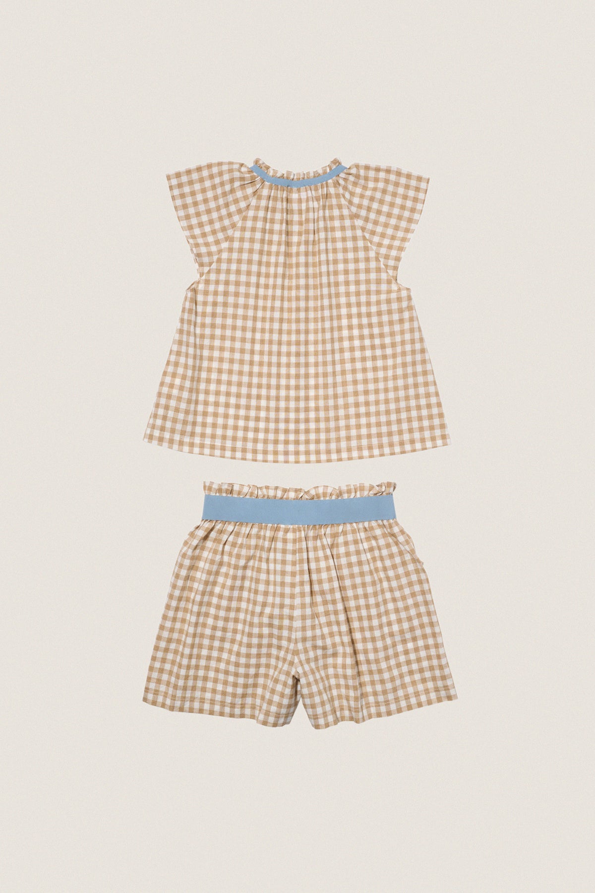 Camel Check Cecil Short Set, a classic gingham two-piece with effortless style. Features a ruffled blouse and elastic shorts, perfect for fun, high-end summer outings.