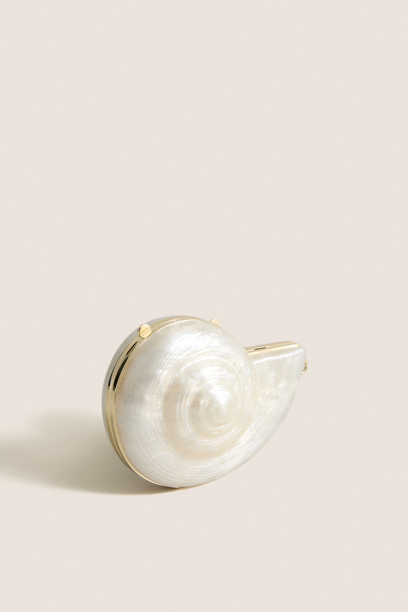Pearl Marion Shell Clutch, a classic, high-end spiral seashell clutch with polished metal trim, offering effortless versatility and fun elegance for any outfit.