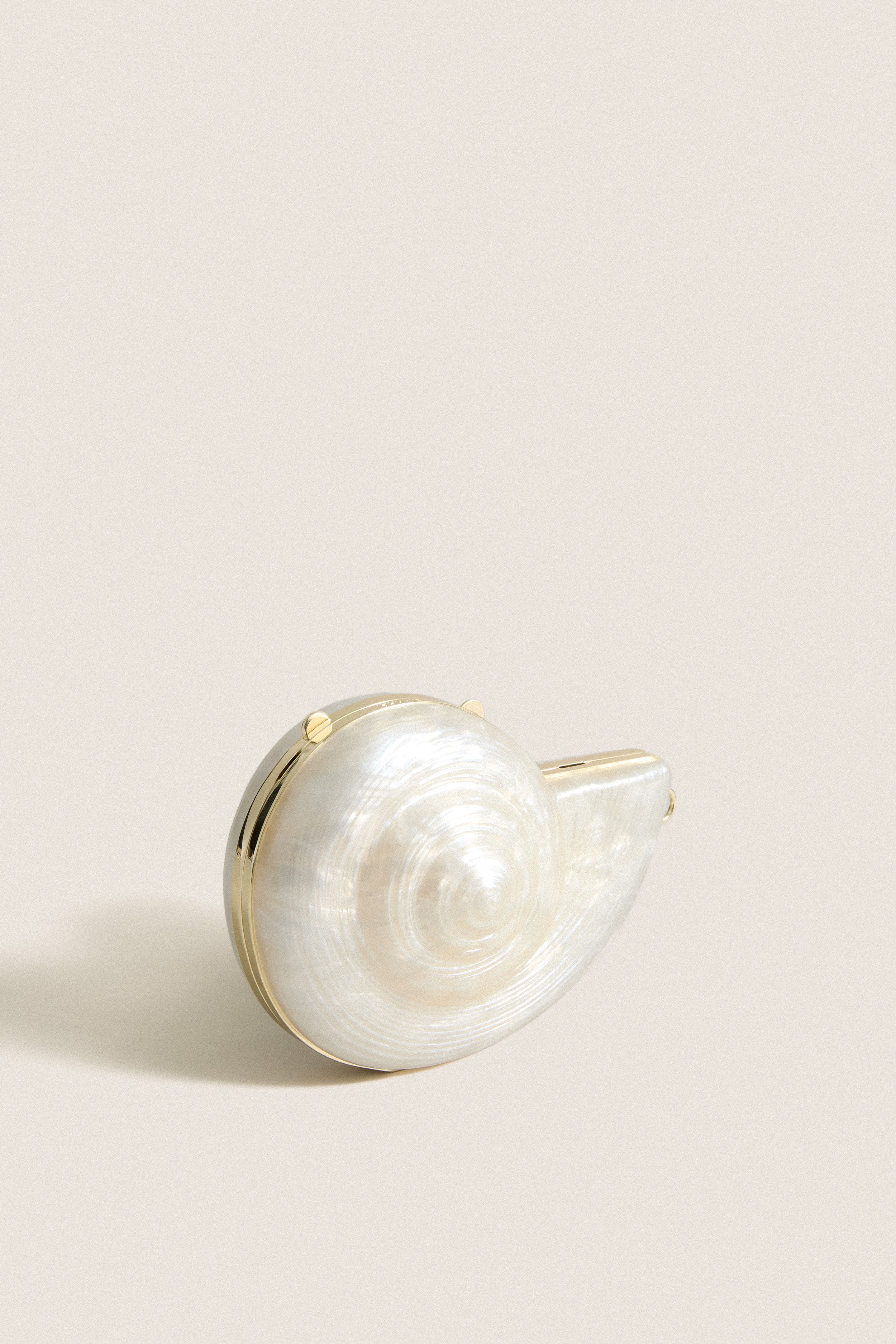 Pearl Marion Shell Clutch, a classic, high-end spiral seashell clutch with polished metal trim, offering effortless versatility and fun elegance for any outfit.