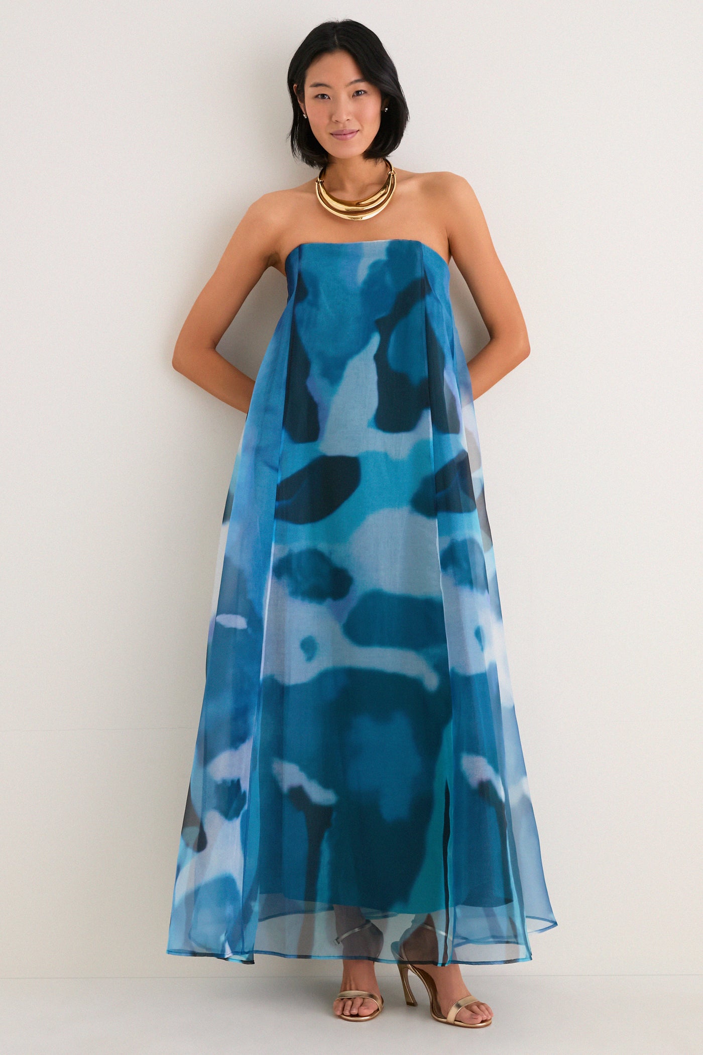 Model in a strapless Blue Haze Allyson Dress, featuring an effortless maxi silhouette with a built-in corset, styled with gold accessories for a classic, high-end look.