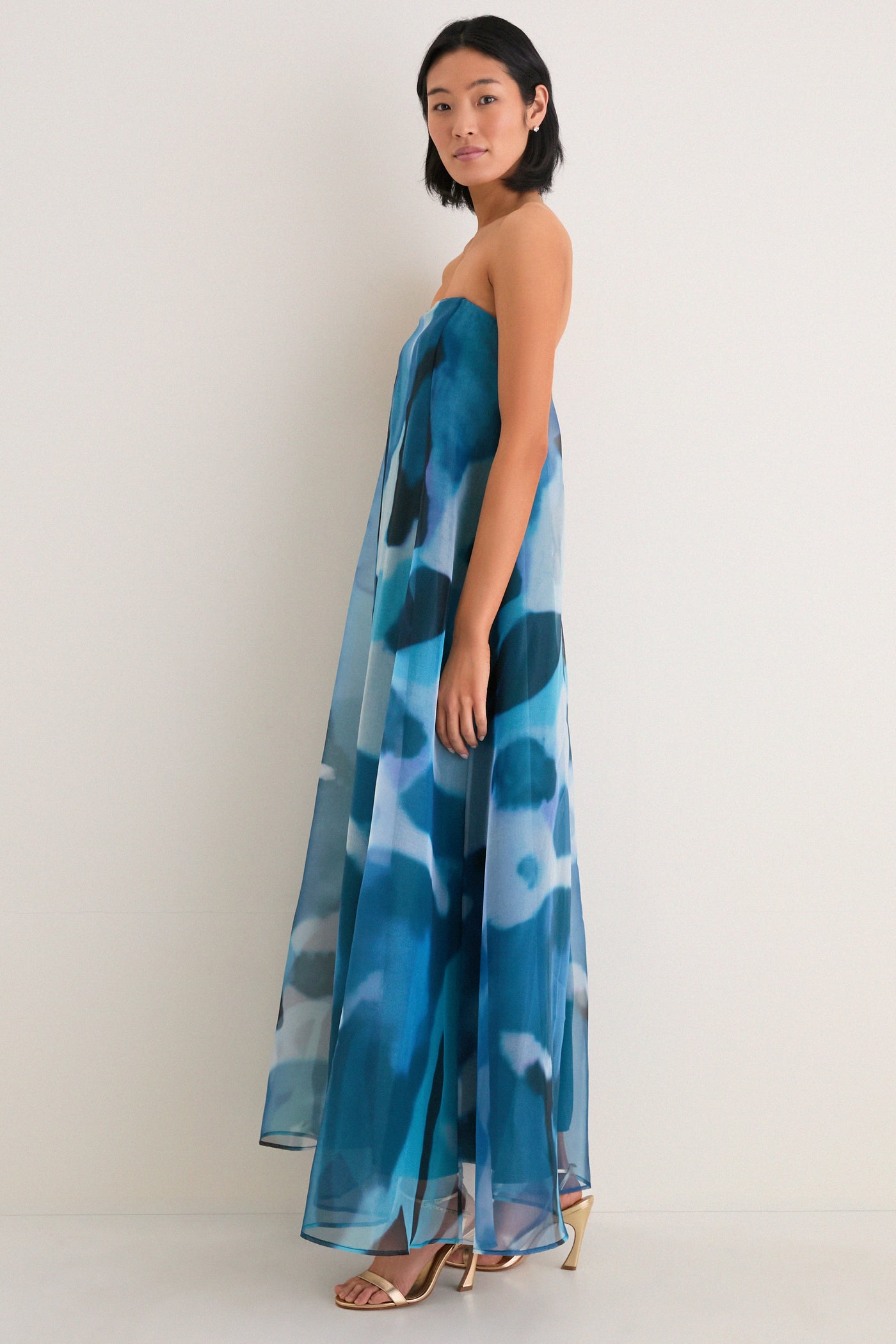 Blue Haze Allyson Dress: A classic, high-end strapless gown with effortless elegance, featuring a sheer overlay and internal corset. Perfectly paired with fun, metallic gold sandals.