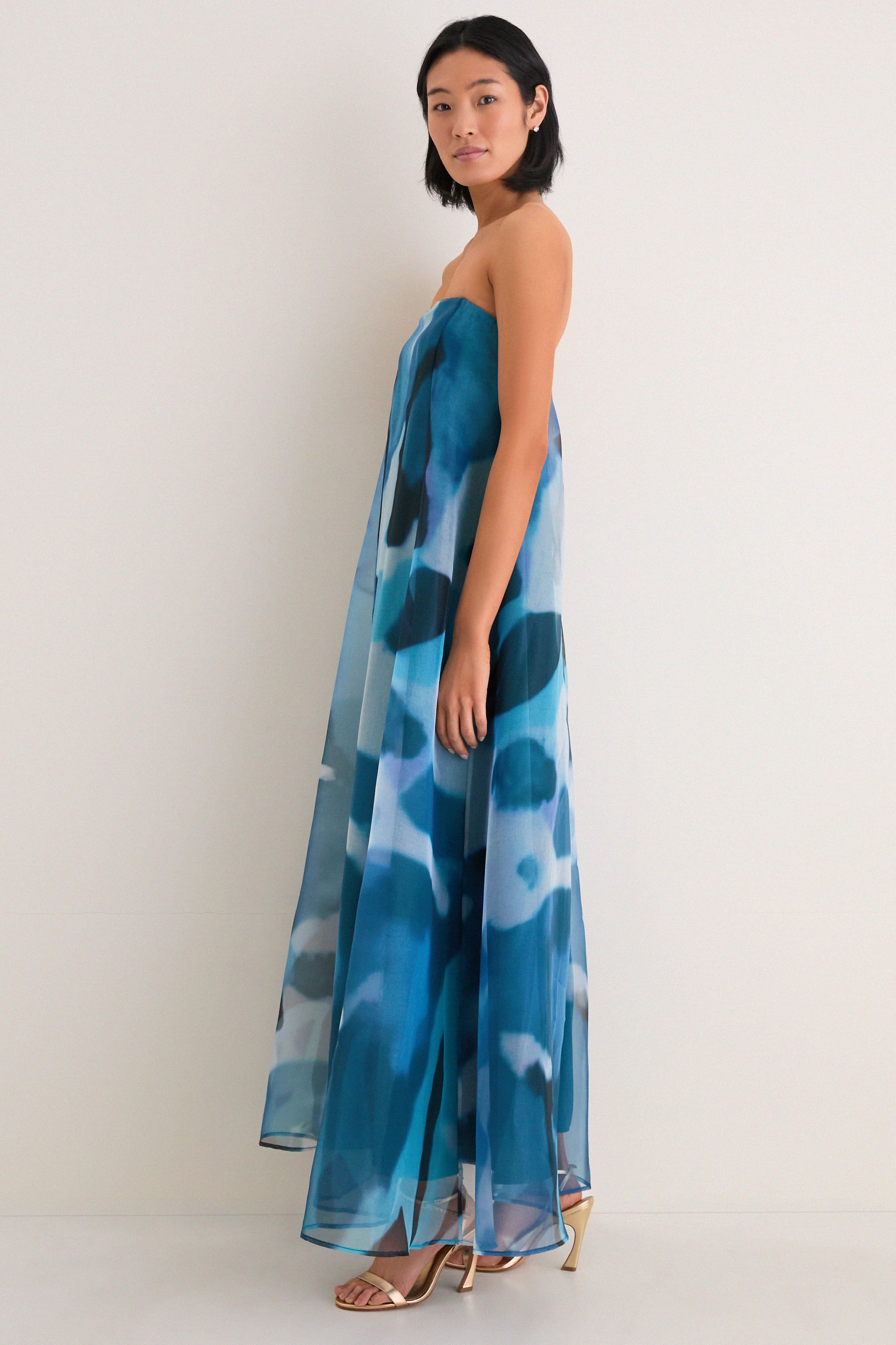 Blue Haze Allyson Dress: A classic, high-end strapless gown with effortless elegance, featuring a sheer overlay and internal corset. Perfectly paired with fun, metallic gold sandals.