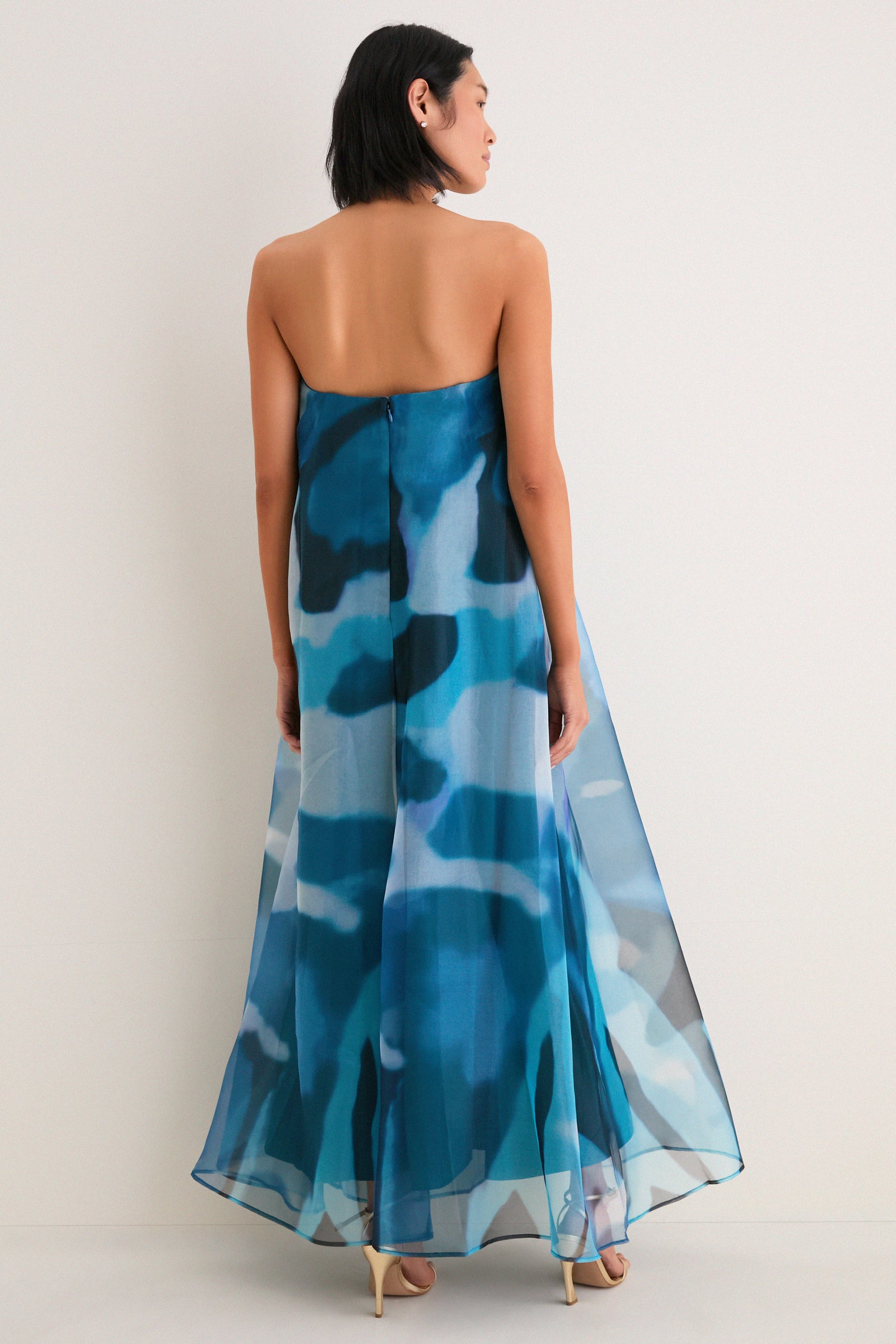 Woman in Blue Haze Allyson Dress: a classic, strapless maxi with effortless, high-end style, showcasing a watercolor pattern and elegant, flowing silhouette.