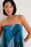 Young woman models the Blue Haze Allyson Dress, a classic, high-end strapless maxi with an effortless, fun style and built-in corset for structure.