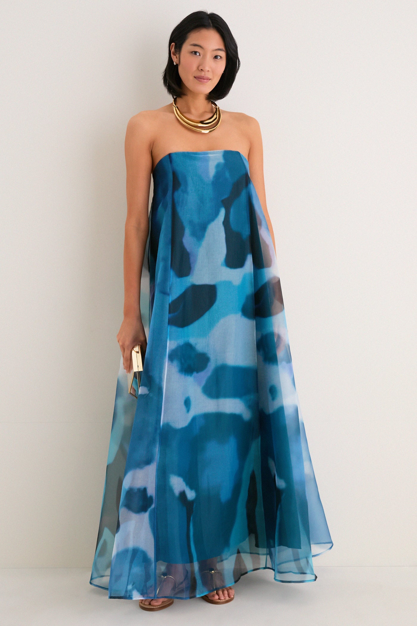 Blue Haze Allyson Dress exudes effortless elegance, featuring a classic strapless design with a flowing tent silhouette. Styled with high-end gold accessories for a fun, polished look.