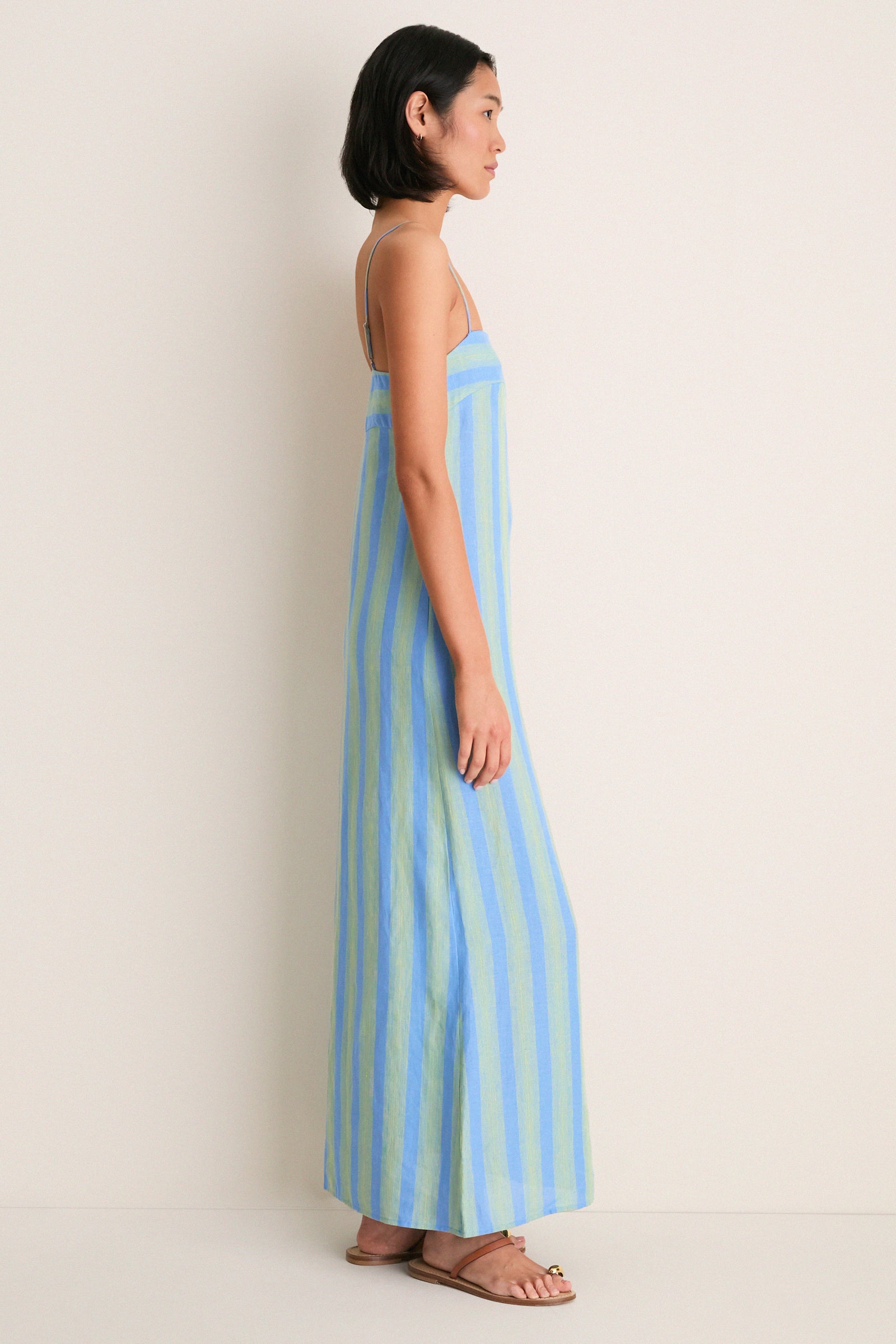 Seaport Stripe Laura Linen Dress: A classic, effortless floor-length sundress with pale blue and green stripes, square neckline, and adjustable spaghetti straps for a fun, high-end look.
