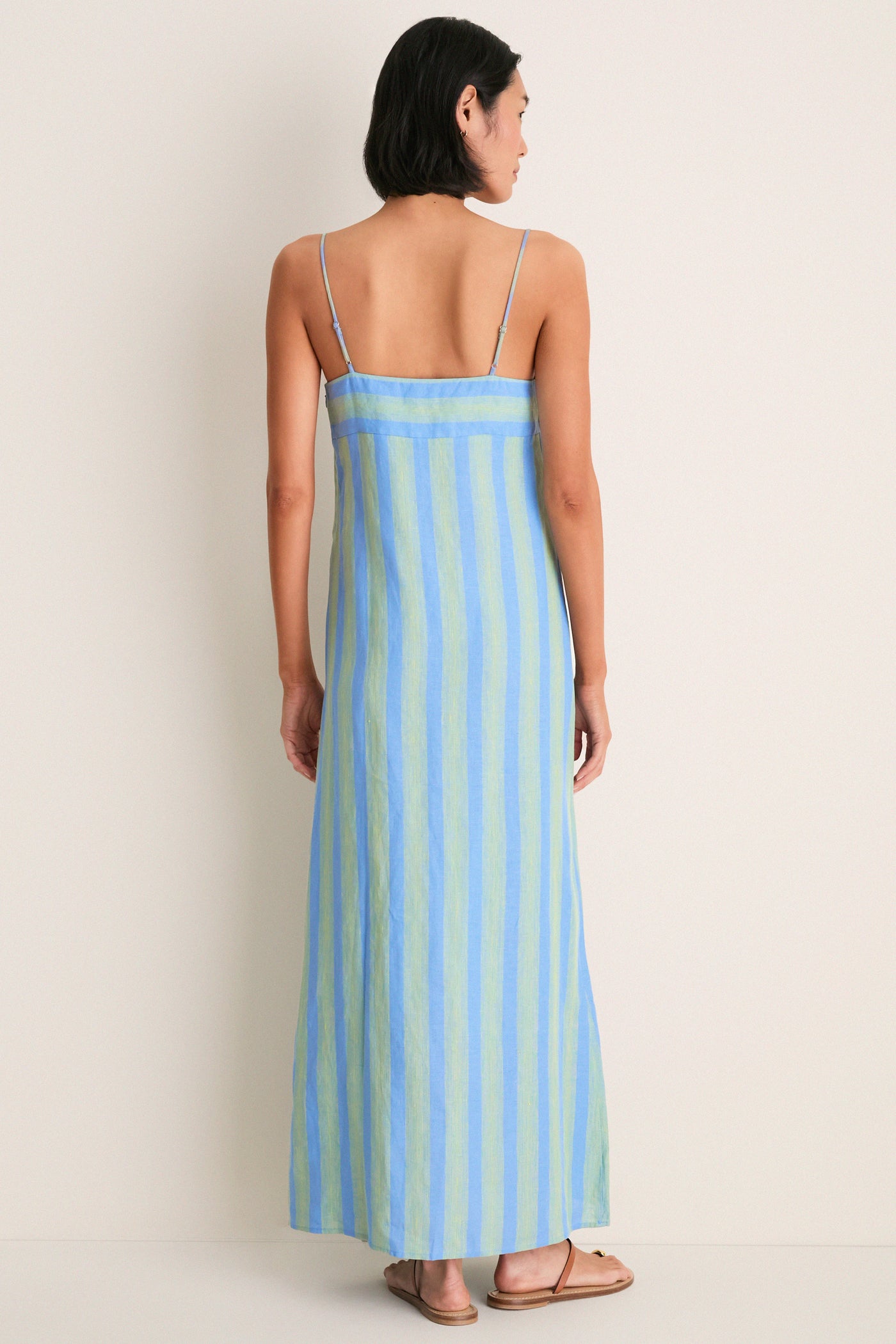 Seaport Stripe Laura Linen Dress showcases a classic, effortless style with its maxi length and adjustable straps, perfect for a high-end, fun coastal vibe.