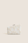 Garden Party Carmella Beaded Clutch, showcasing classic, high-end beadwork with floral motifs and effortless design, featuring a playful asymmetrical shape and removable chain strap.