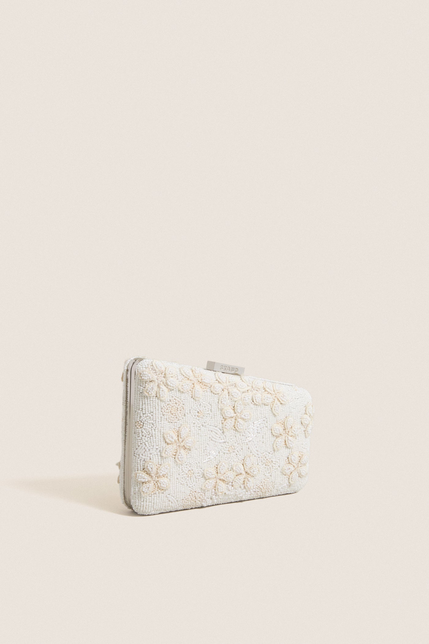 Garden Party Carmella Beaded Clutch with classic off-white floral beadwork, effortless asymmetrical design, and fun removable chain strap, exuding high-end elegance for versatile occasions.
