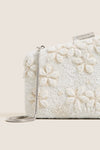 Garden Party Carmella Beaded Clutch with intricate floral beadwork, silver snake-chain strap, and metallic STAUD logo, exuding classic, effortless, and high-end style.
