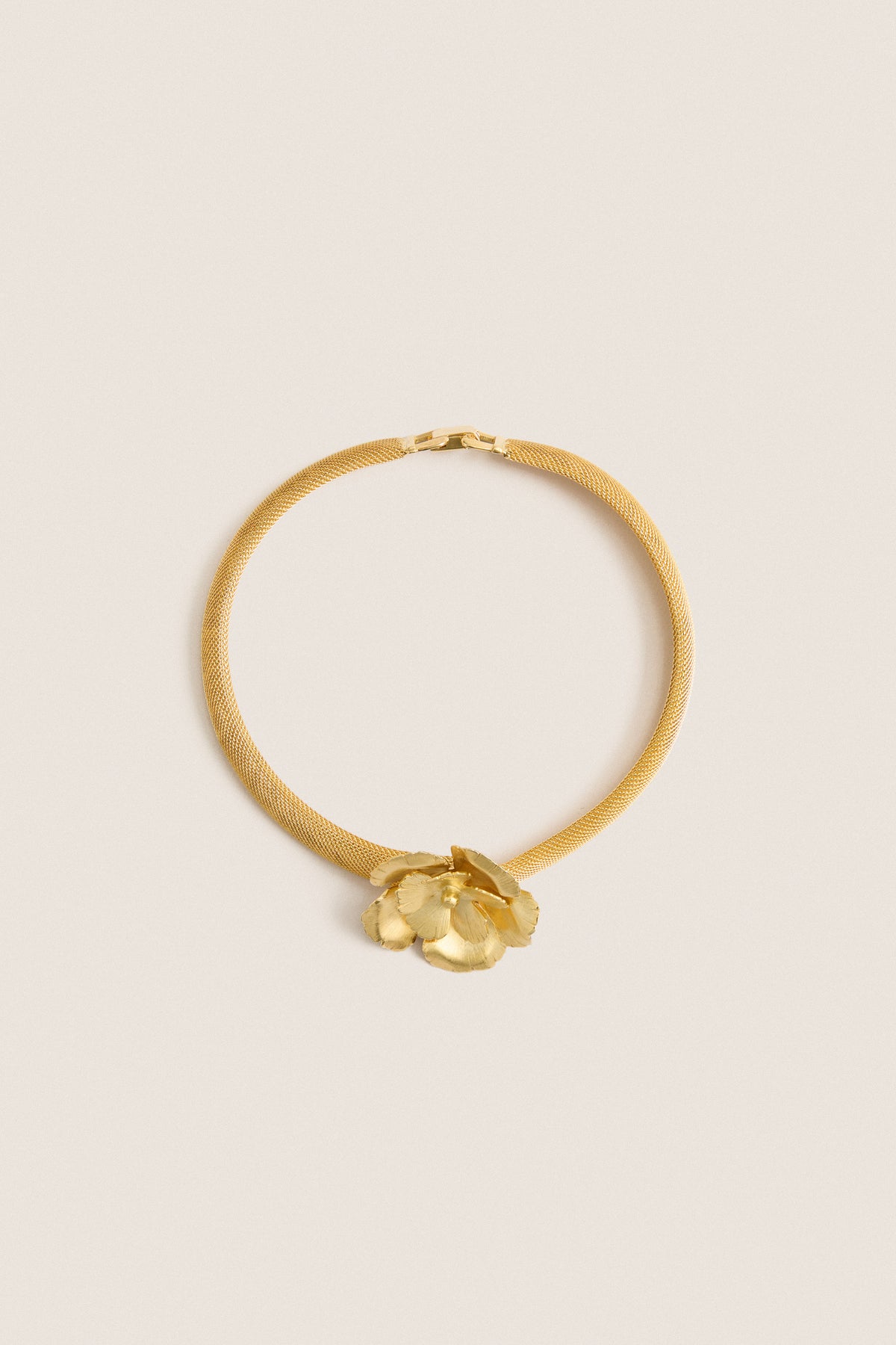 Antique Gold Eden Mesh Choker featuring a classic gold-tone mesh band with a sculpted flower centerpiece, offering an effortless, high-end touch for fun, confident styling.