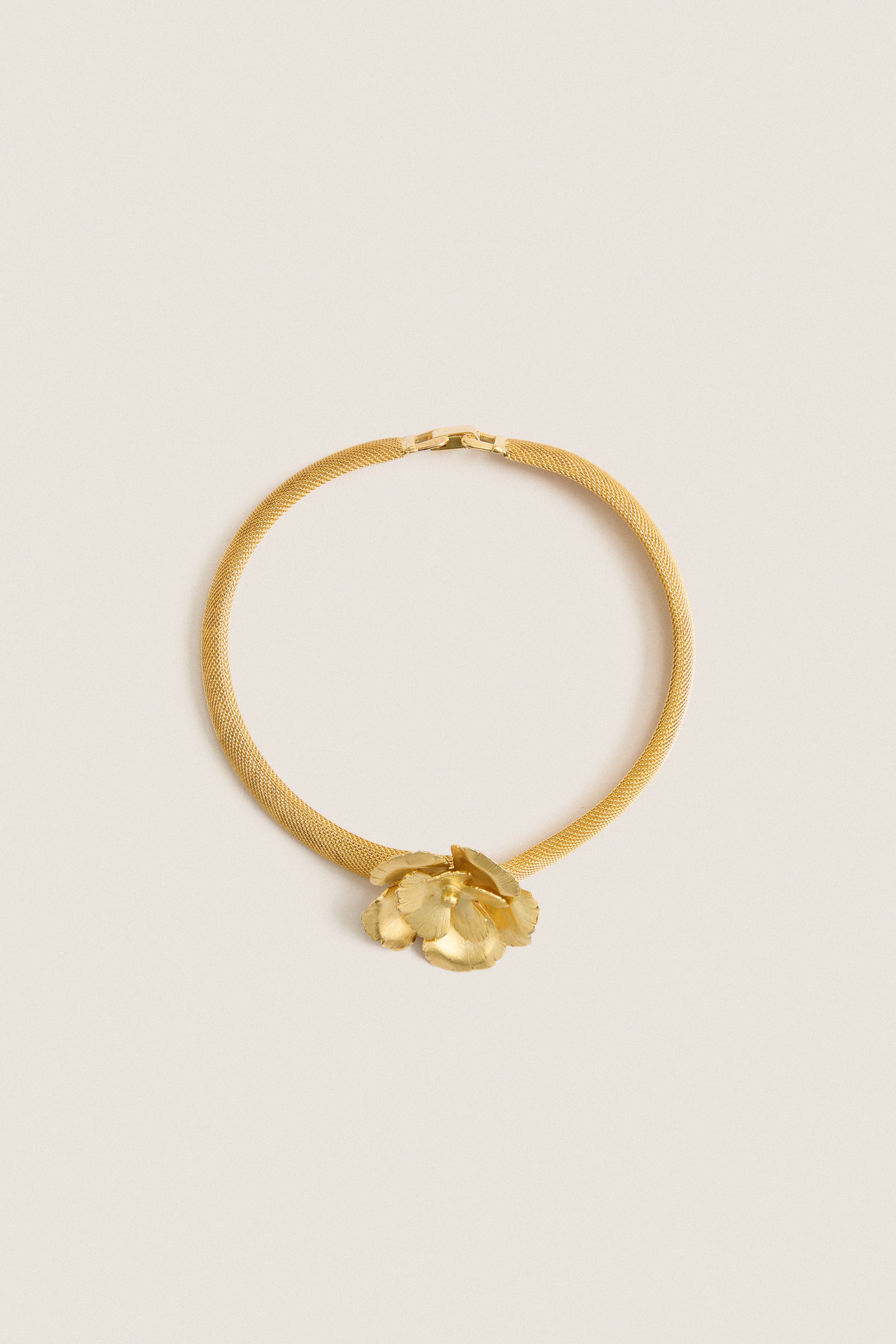 Antique Gold Eden Mesh Choker featuring a classic gold-tone mesh band with a sculpted flower centerpiece, offering an effortless, high-end touch for fun, confident styling.