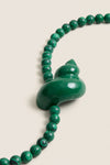 Green Mykonos Necklace featuring classic malachite beads and a sculptural enamel swirl pendant; an effortless, high-end piece perfect for fun, stylish outings.
