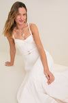 Young woman in a classic, sleeveless Off White Fiona Dress with fitted bodice and full skirt, accessorized with a gold pendant necklace, exuding effortless, high-end style.