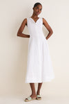 A slim woman models a White Cotton Boat Neck Dress, exuding effortless elegance with its classic sleeveless design, ideal for high-end, fun, warm-weather styling.