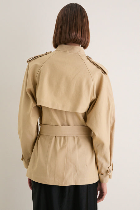 Back view of a person in a Classic Camel Cotton Field Jacket, featuring a chic trench style with epaulettes and a belted waist for an effortless, high-end look.