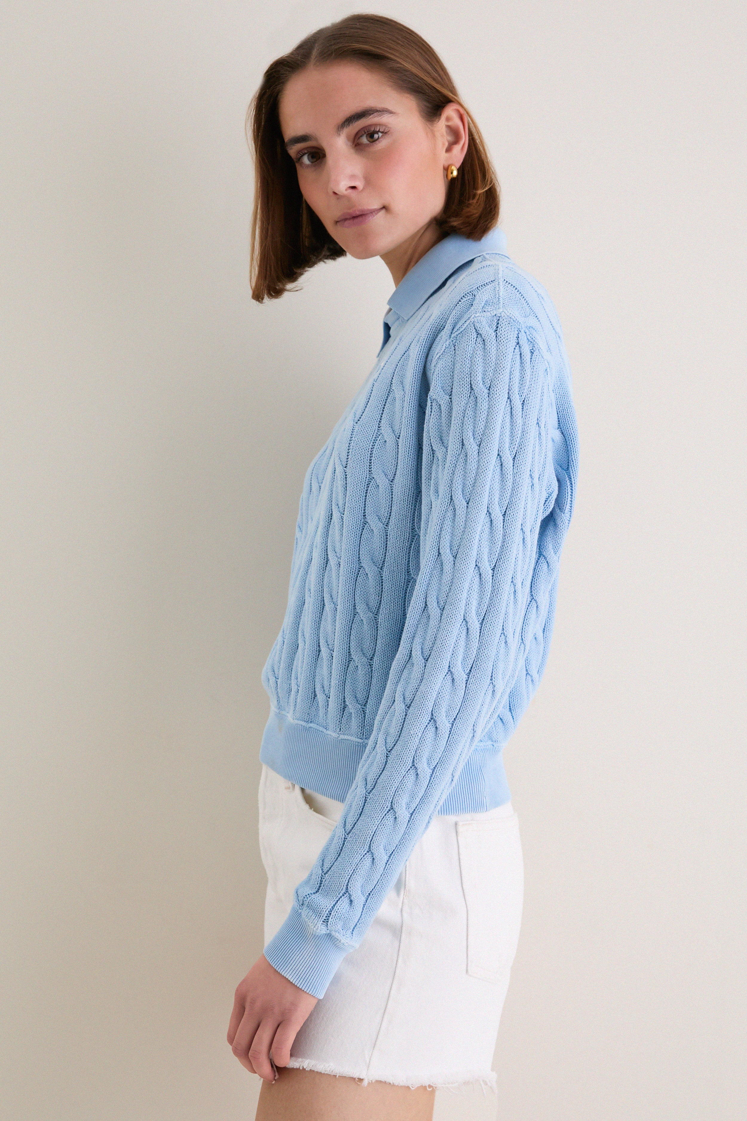 Young woman in profile wearing Polo Ralph Lauren's Chambray Blue Cotton Knit Polo, showcasing its classic cable-knit design and effortless, high-end style with a vintage-inspired finish.