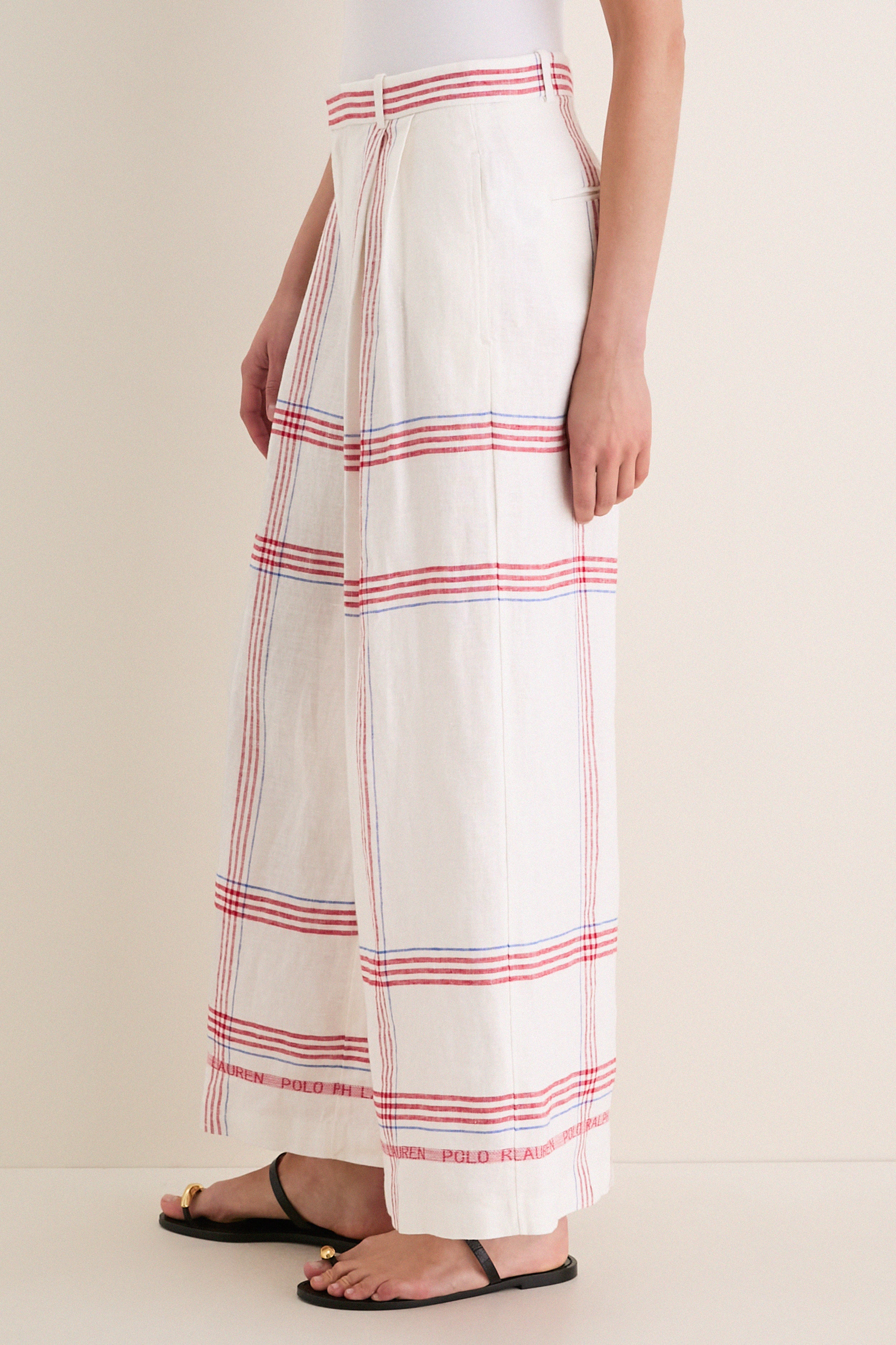 Wide-leg trousers in white linen with plaid pattern, featuring subtle Polo Ralph Lauren branding, styled with black sandals for a classic, effortless, high-end look.