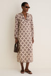 Model wears Brown Tortoise Lyric Leigh Sunglasses, embodying classic elegance with an effortless vibe, paired with a patterned dress, gold accessories, and a chic handbag.