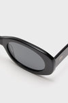 Gloss Black Lyna Sunglasses with oval acetate frame and dark tinted lenses, featuring a chic gold M logo on the temple, exude effortless, high-end style.