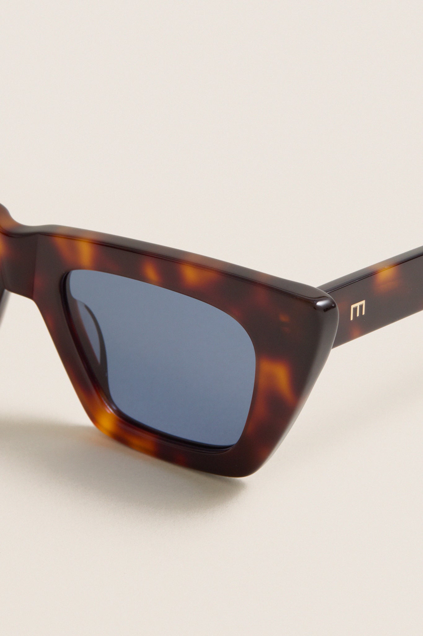 Brown Tortoise Dark Blue Lens Lori Sunglasses exude a classic, effortless charm with their chic cat-eye design, featuring high-end tortoiseshell frames and gold-tone M logo detail.