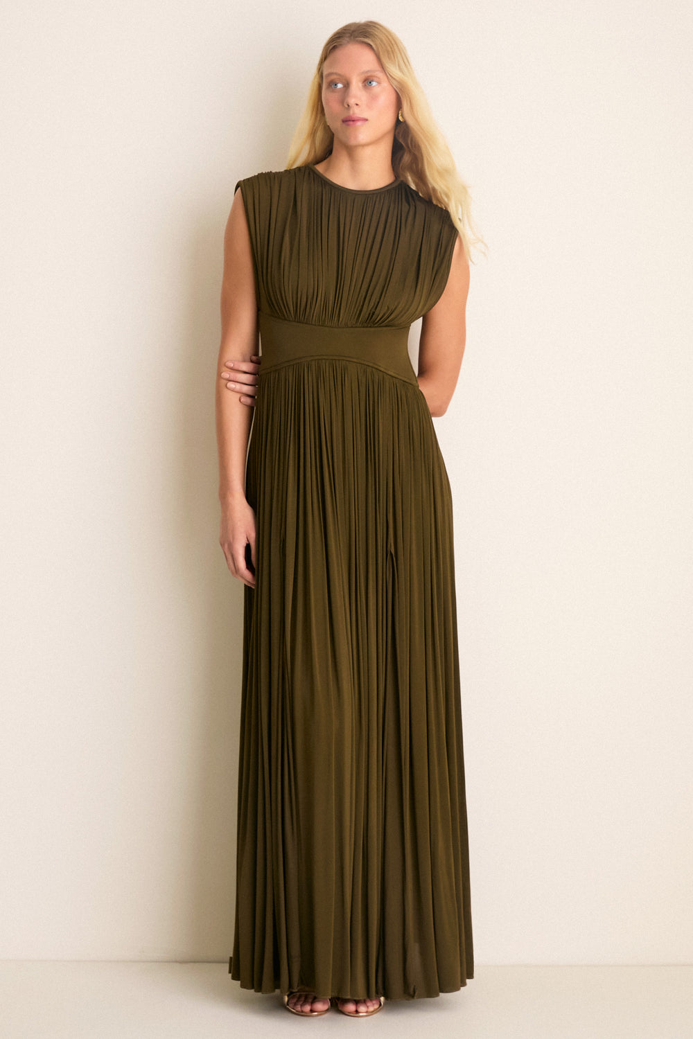 A model effortlessly showcases the classic, high-end Olive Luna Column Dress, featuring a pleated bodice, fixed waistband, and elegant front skirt splits.