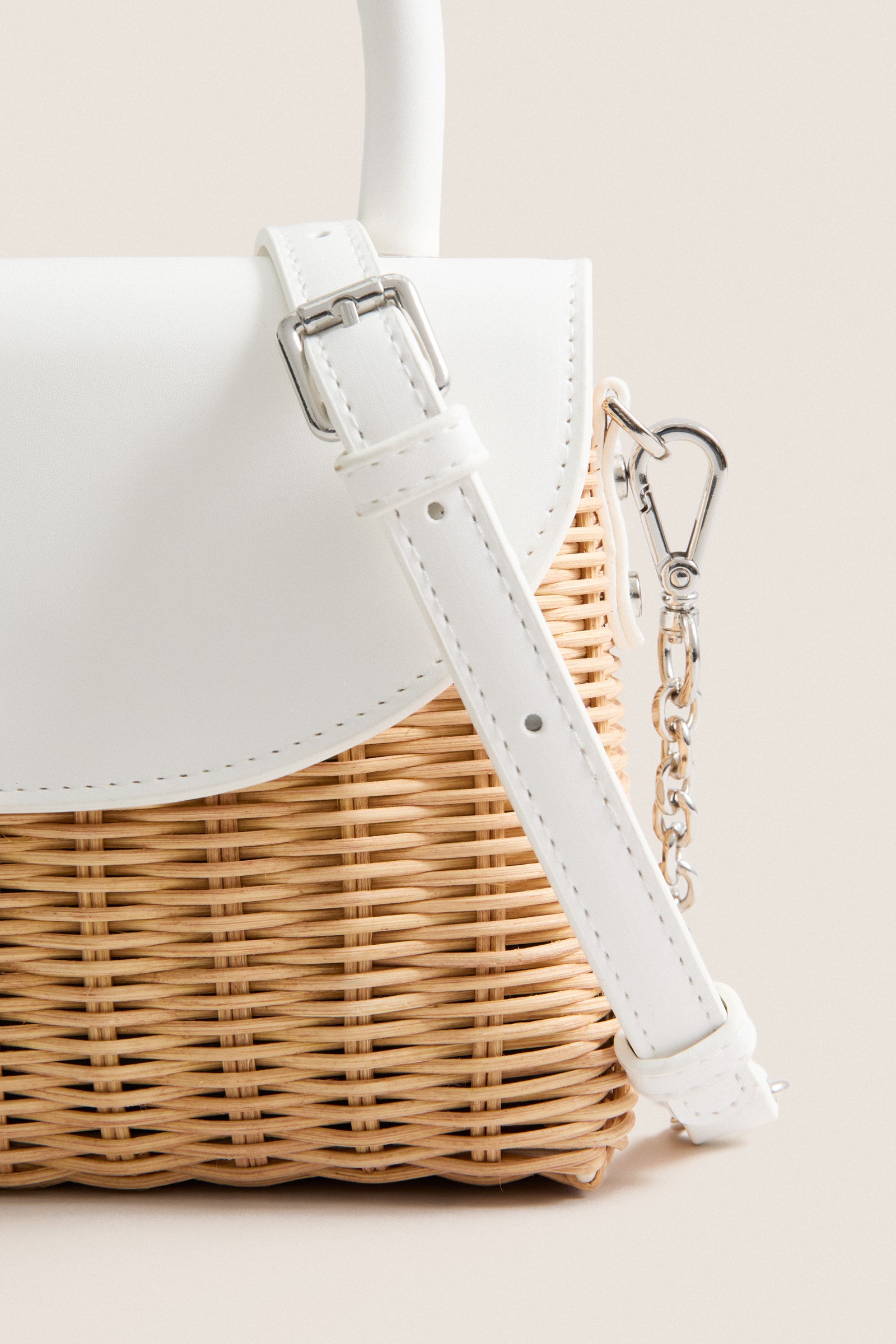 White Elle Wicker Top Handle bag with sleek vegan leather accents and silver details, offering a classic, effortless, and fun style for high-end summer occasions.
