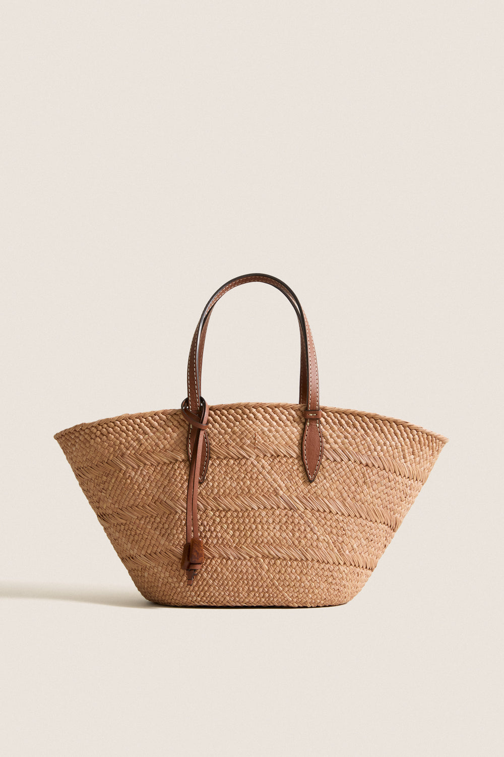 Nuez and Cognac Small Trapeze Basket, classic woven straw tote featuring effortless leather handles and tie, perfect for fun, high-end style with handwoven craftsmanship.