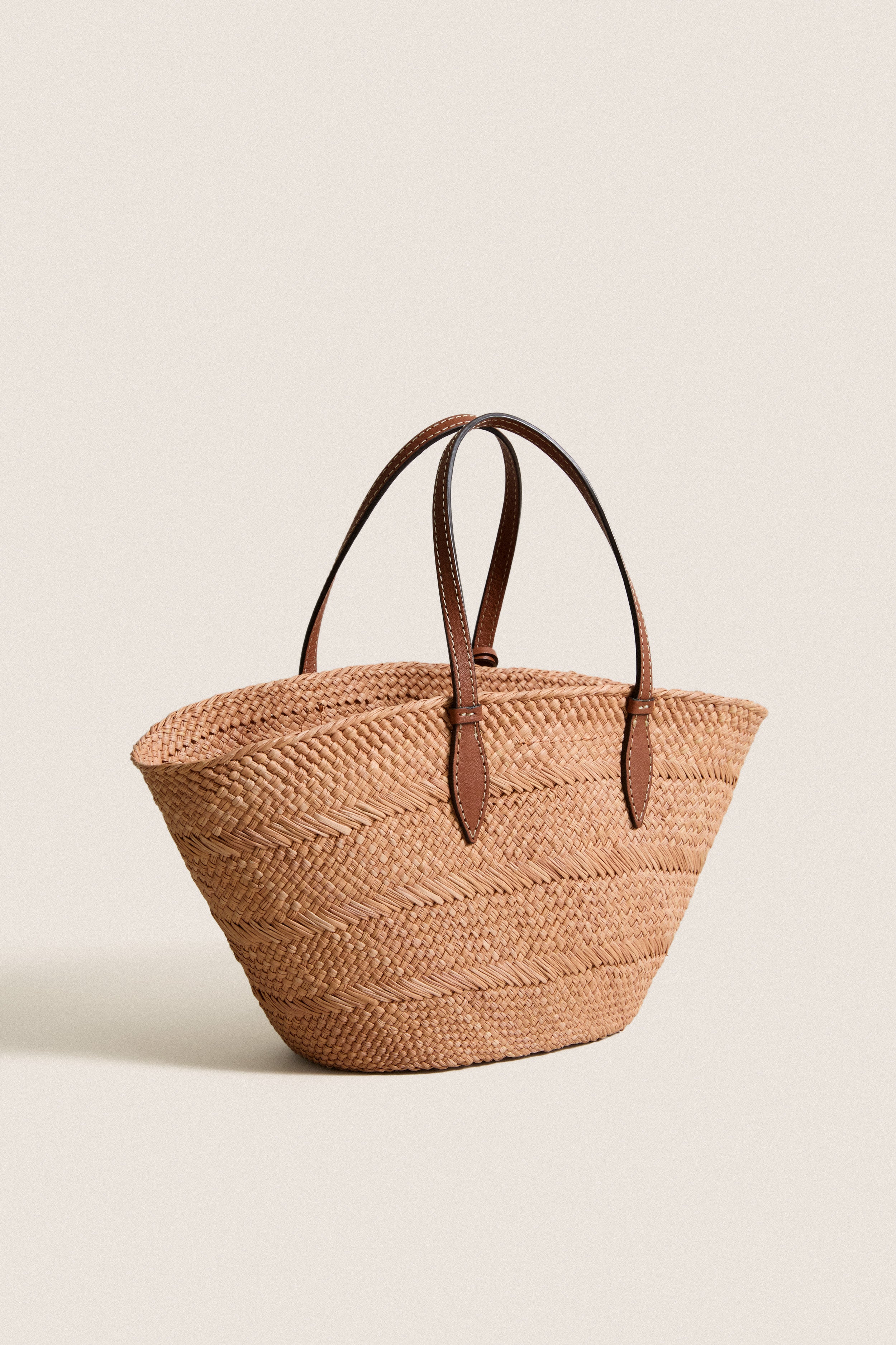 Nuez and Cognac Small Trapeze Basket: A classic, high-end woven straw tote with leather handles, offering effortless style and fun for market days or warm weather adventures.