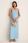 Woman models Nuez and Cognac Small Trapeze Basket, an effortless handwoven tote with cognac leather straps, capturing a classic, high-end beach-ready style with fun, summery appeal.