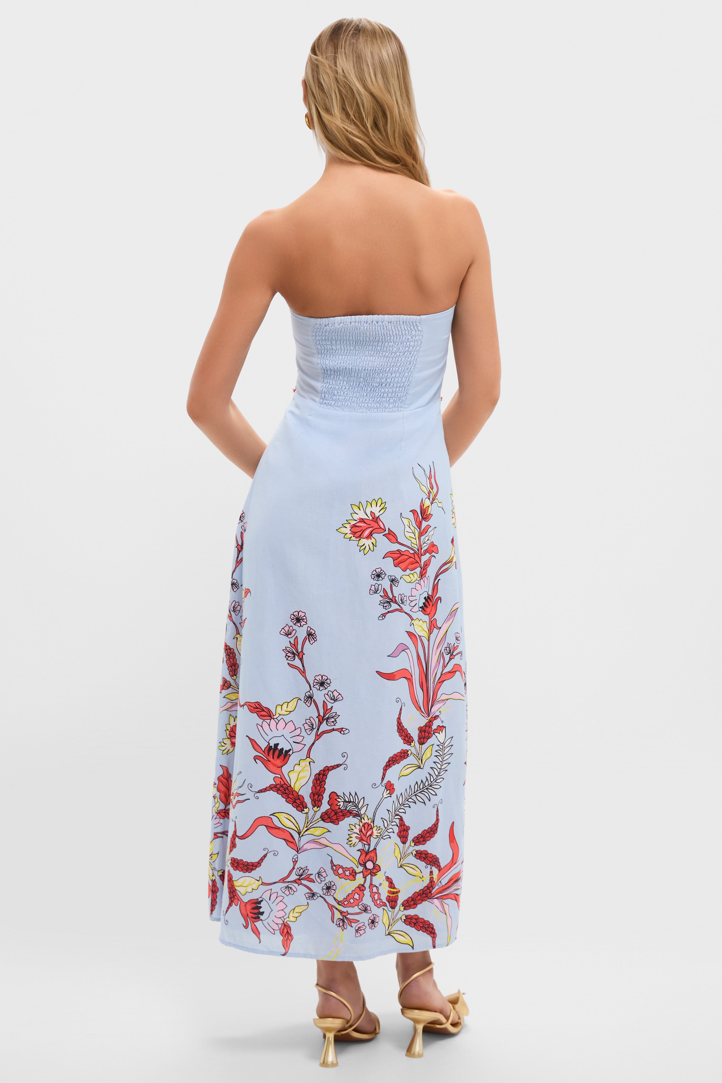 Seascape Hayden Midi Dress, back view: Classic strapless design with smocked bodice, floral A-line skirt, and gold heeled sandals, creating an effortless, high-end, and fun style.