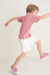 Young child wearing the classic Nantucket Red and Creme Le Club Polo, showcasing its effortless, high-end style as he joyfully runs, embodying fun and comfort.
