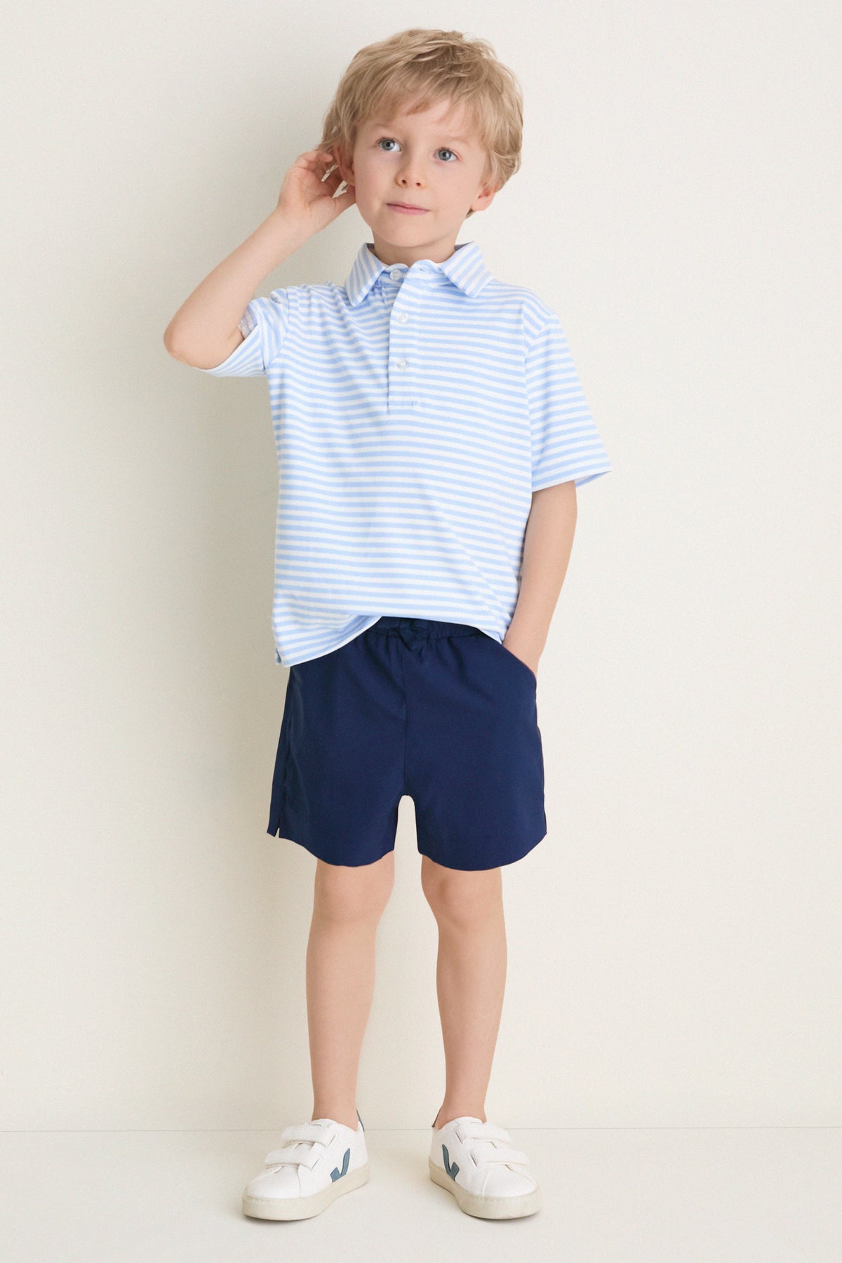 Young boy wearing the classic Bachelor's Blue and White Le Club Polo with navy shorts and white sneakers, embodying an effortless, fun, and high-end style.
