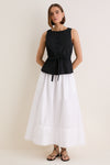Woman models the Black Cotton Poplin Francoise Top, showcasing its classic high neckline and effortless cinched waist, paired with a flowing skirt for a high-end, fun look.