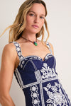 Woman wearing the classic Blue and White Richilieu Midi Dress, featuring effortless floral embroidery and a fun, high-end fit-and-flare silhouette with lace-trimmed straps.