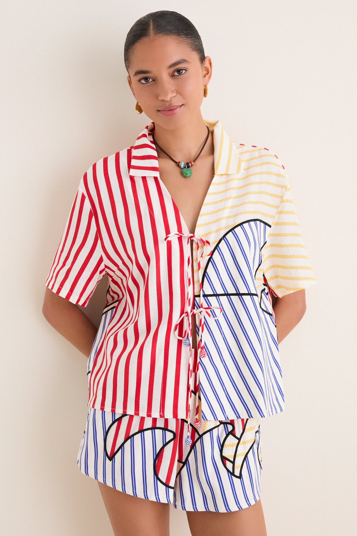 Young woman in a classic, effortless Navy Stripes Off-White Tie Front Blouse with playful multi-colored stripes, embodying high-end, fun style.