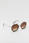 Brown Tortoise Angie Sunglasses with classic hexagonal frames, gradient brown lenses, and slender gold-tone temples, exude effortless, high-end style for a fun, confident look.