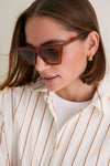 Woman models Cider Lisbon Sunglasses, showcasing a classic cat-eye design with a chic, high-end flair. These oversized frames offer an effortless, fun style, perfect for everyday wear.