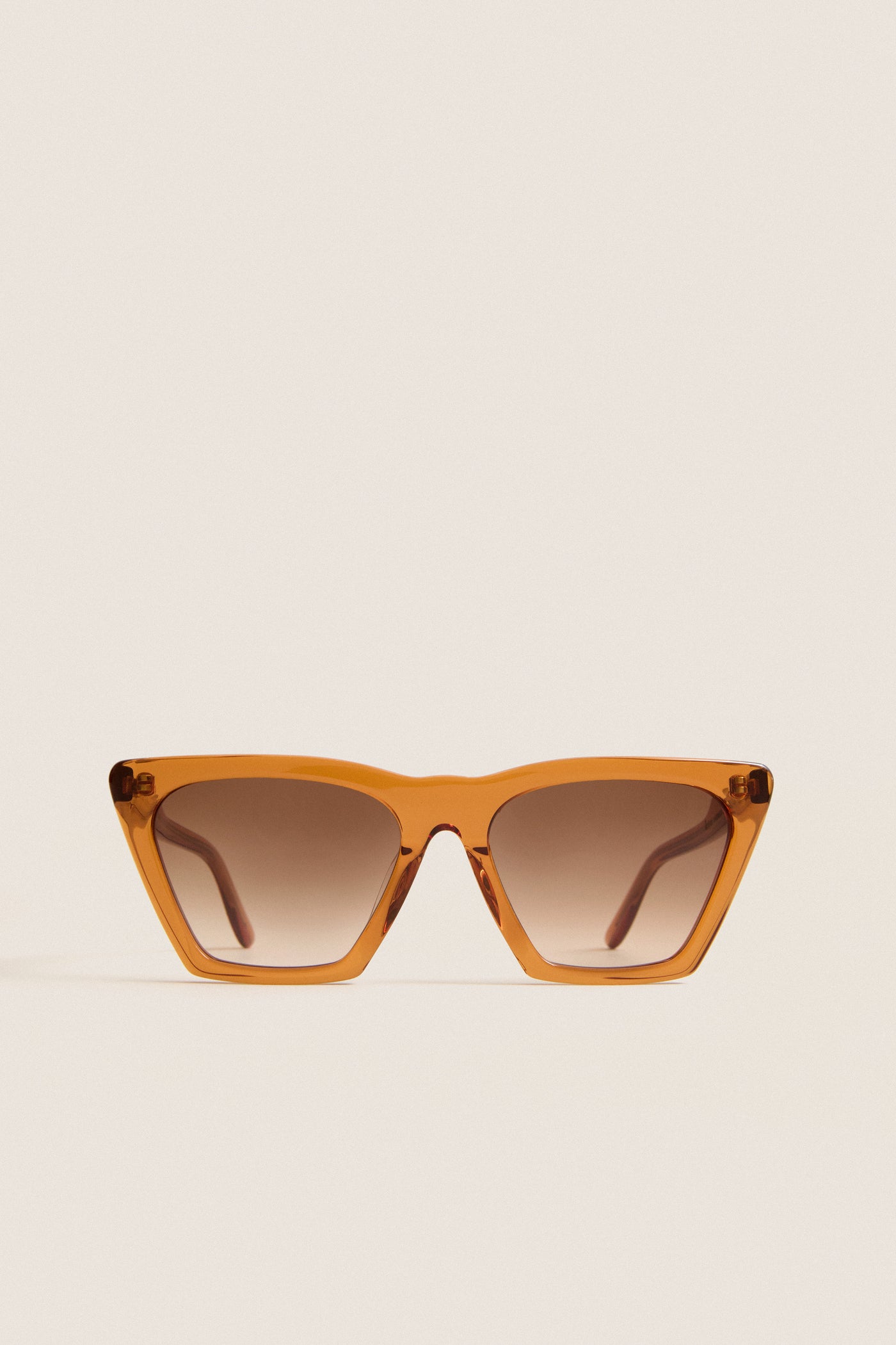 Cider Lisbon Sunglasses feature a classic, effortless cat-eye shape with translucent amber-orange frames, ideal for fun, high-end adventures. Perfect for confident, everyday style.