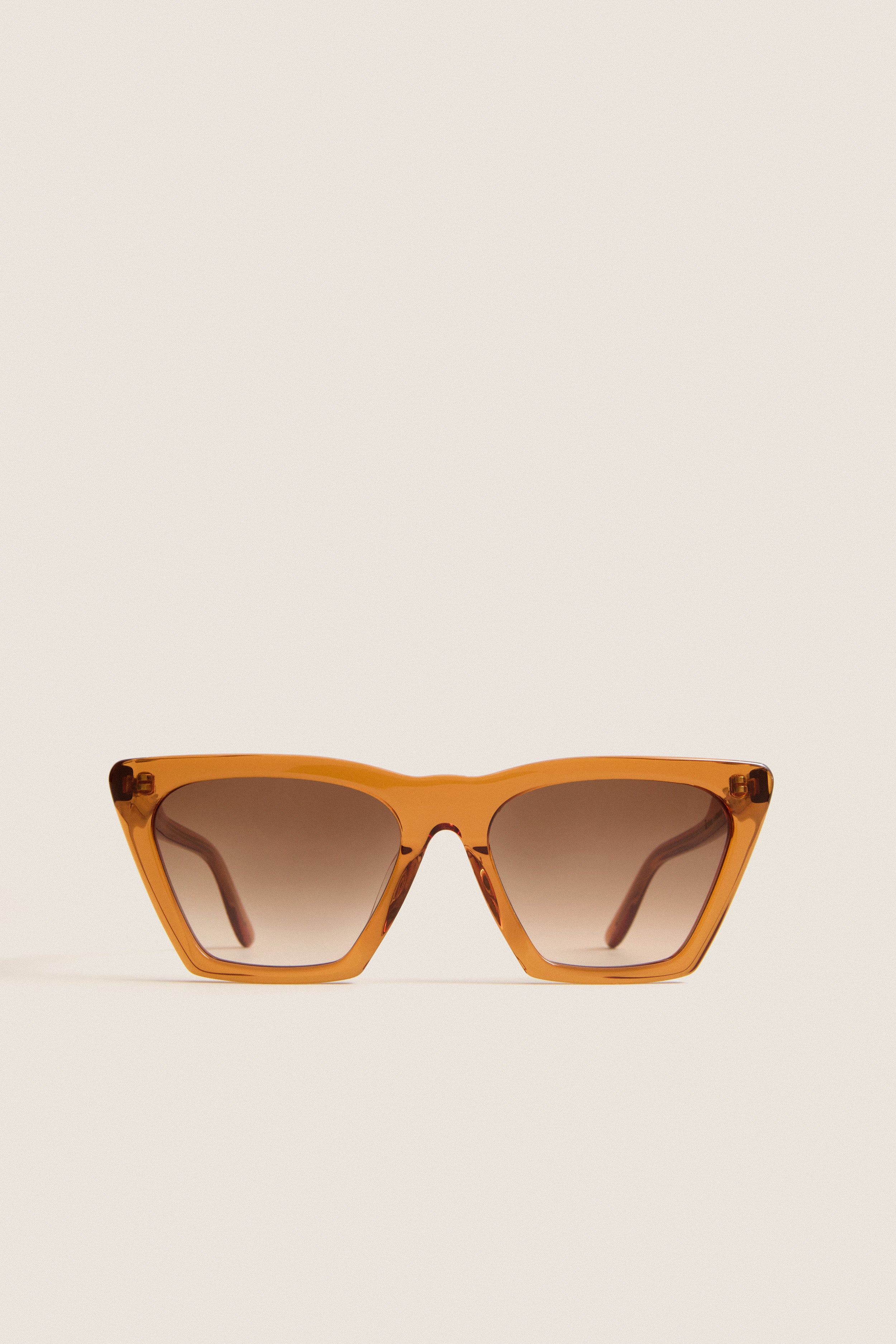 Cider Lisbon Sunglasses feature a classic, effortless cat-eye shape with translucent amber-orange frames, ideal for fun, high-end adventures. Perfect for confident, everyday style.