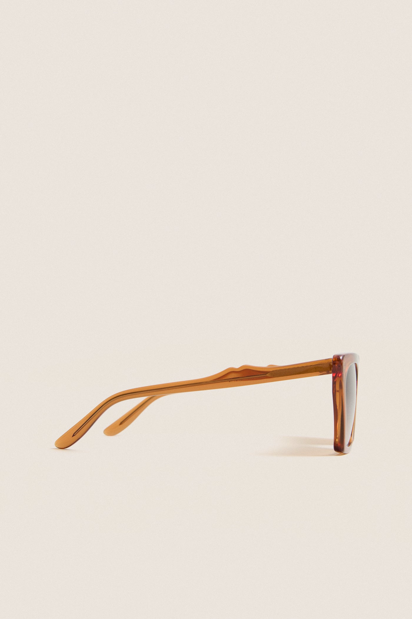 Cider Lisbon Sunglasses in translucent amber, featuring a classic cat-eye silhouette and three-barrel hinge, embodying effortless, high-end style for fun, everyday wear.