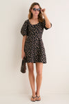 Woman wearing Shiny Black Judy Sunglasses, exuding an effortless, high-end style with her chic black dress and stylish accessories, embodying a classic, fun Tuckernuck vibe.
