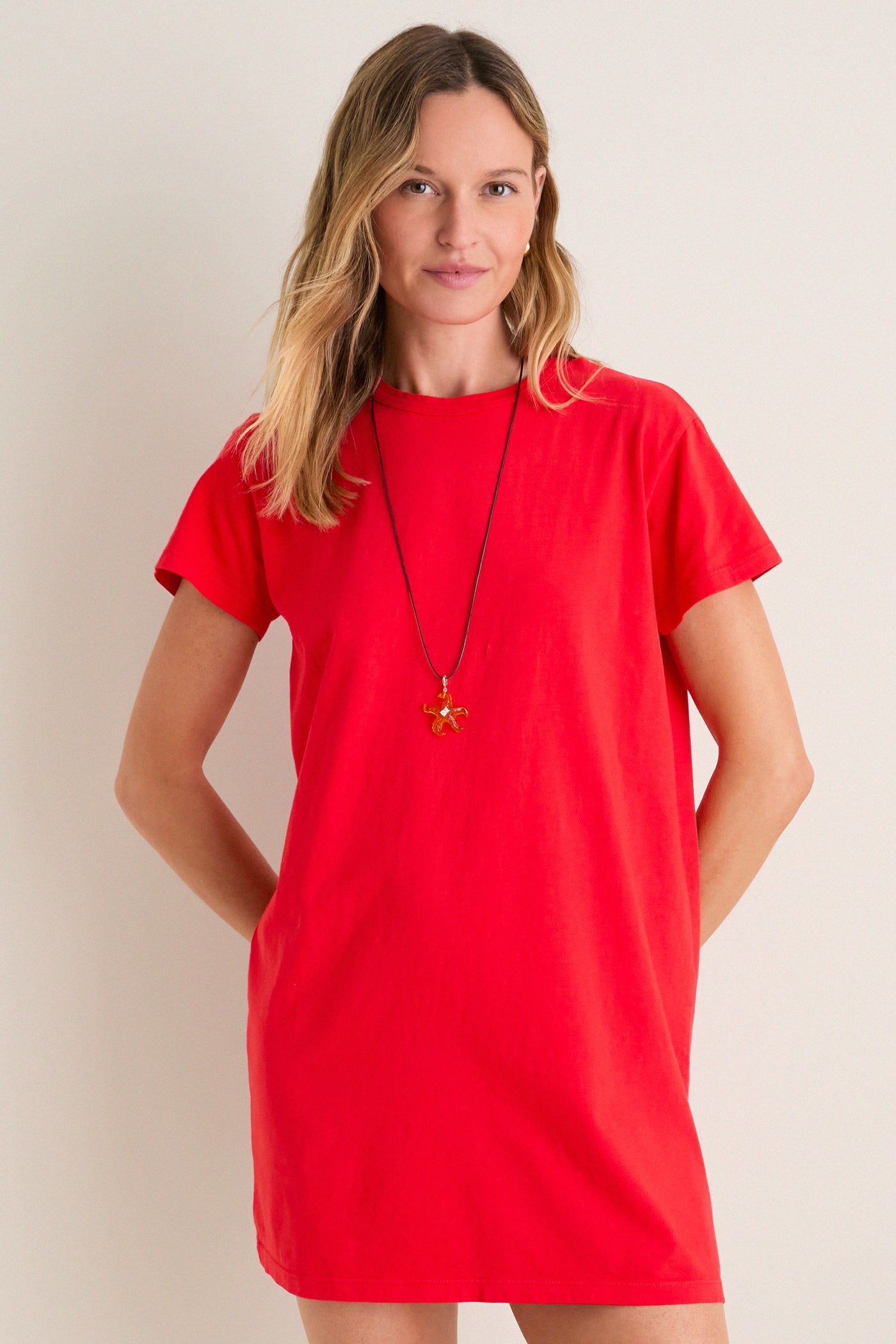Cerise Margo Mini Dress: A classic, effortless T-shirt style in bold red with a fun, high-end silhouette, worn with a starfish pendant necklace.